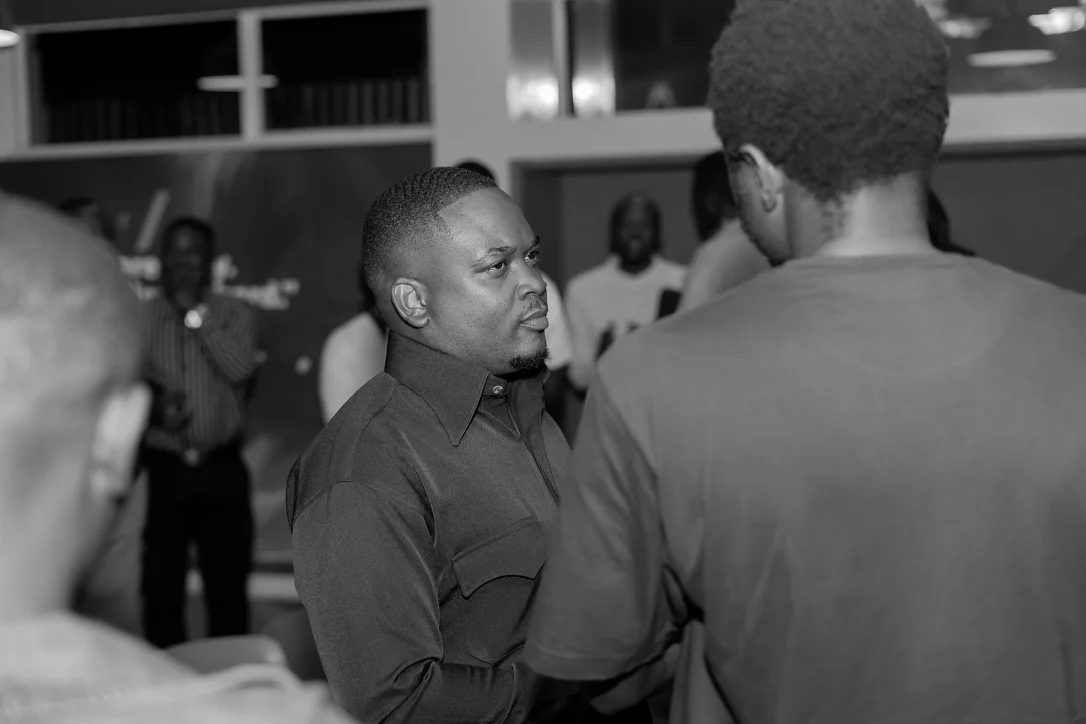 Brian listening to an attendee during a conversation, photographed in black and white